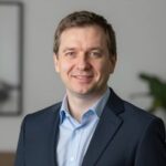 Портрет уверенного российского бизнесмена в студийном освещении на размытом нейтральном фоне