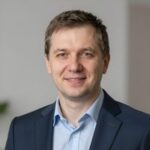 Портрет уверенного российского бизнесмена в студийном освещении на нейтральном размытом фоне
